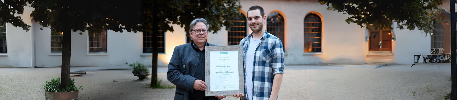 Daniel und Egon Brunner halten ihre Auszeichnung zum Schnapsbrenner des Jahres vor der Inatura in Dornbirn, Vorarlberg.