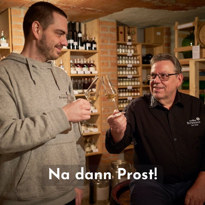 Daniel und Egon der Destillerie Brunner zufrieden beim Anstoßen mit ihrem ausgezeichneten Himbeer Schnaps.