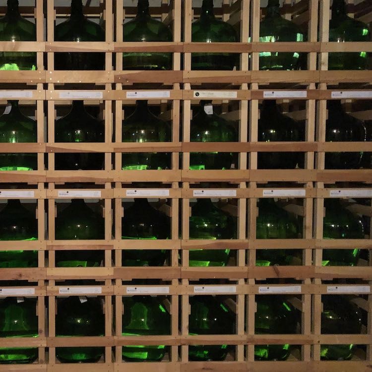 Bild vom "Schnapsgrid" der Destillerie Brunner. Das sind mehr als 60 alte 25 Liter Mostflaschen schön zusammengestellt in eigens gefertigten Gestellen.
