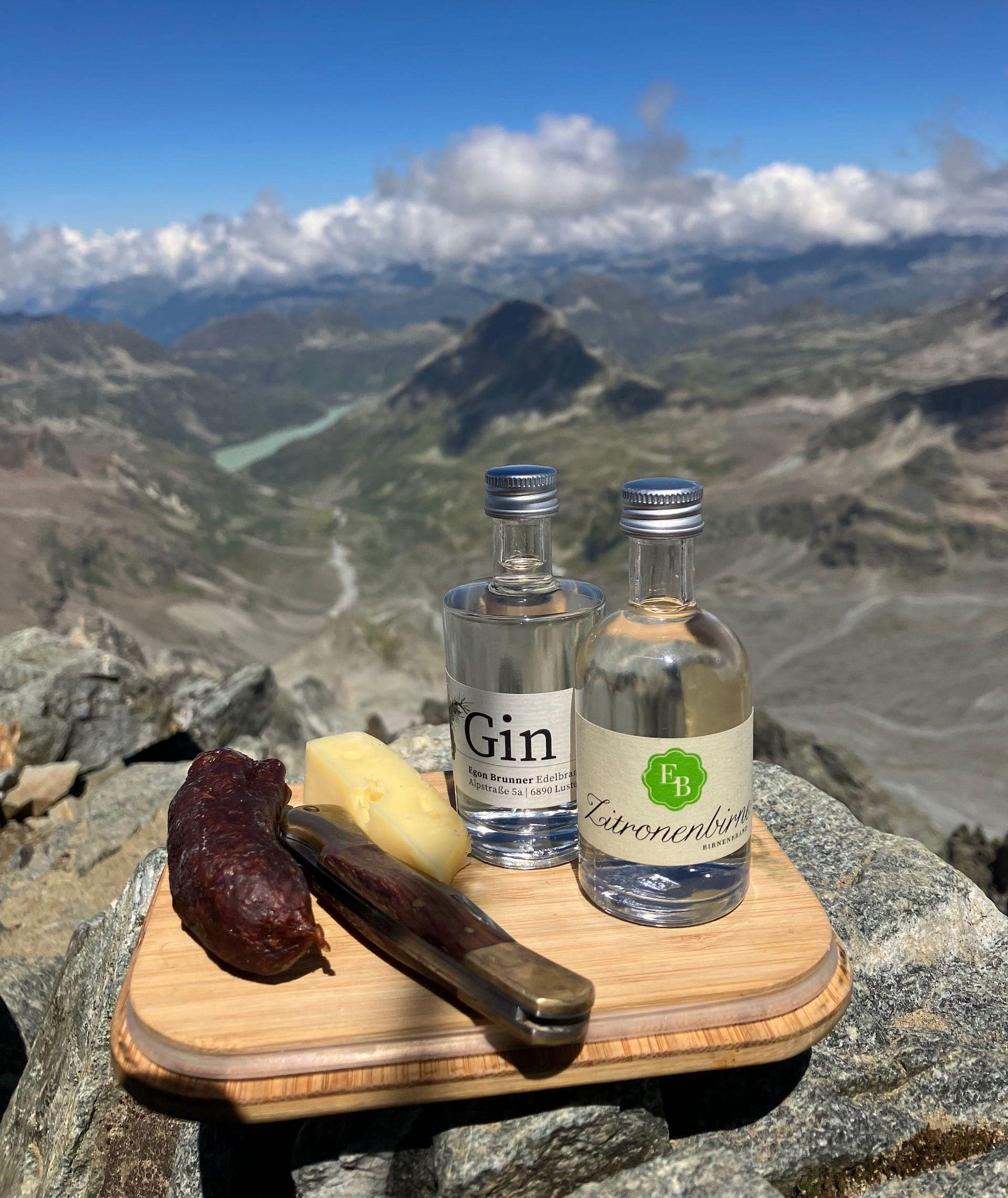 Die Zitronenbirne und der Gin der Destillerie Brunner im Miniflaschenformat auf dem Piz Buin mit Jause und Ausblick auf die Silvretta.