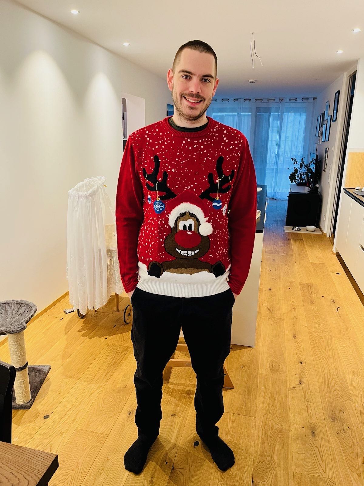 Daniel Brunner schief lächelnd mit einem Christmas Sweater aus Irland.