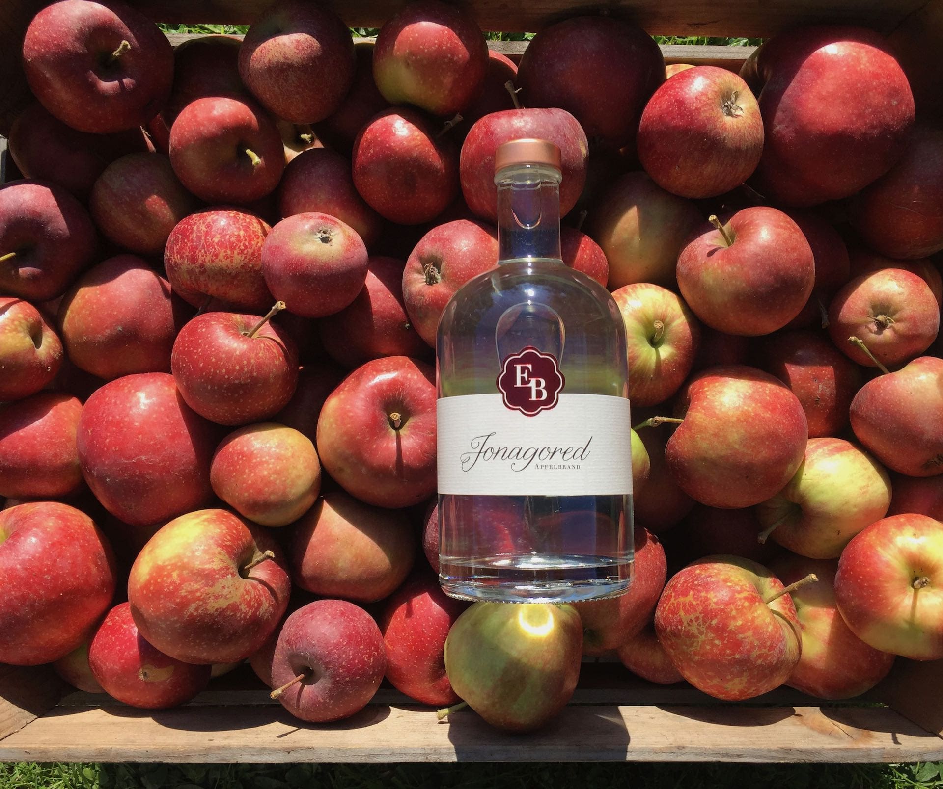 Geerntete Jonagored-Äpfel aus der Bodenseeregion in einer Holzkiste der Destillerie Brunner.