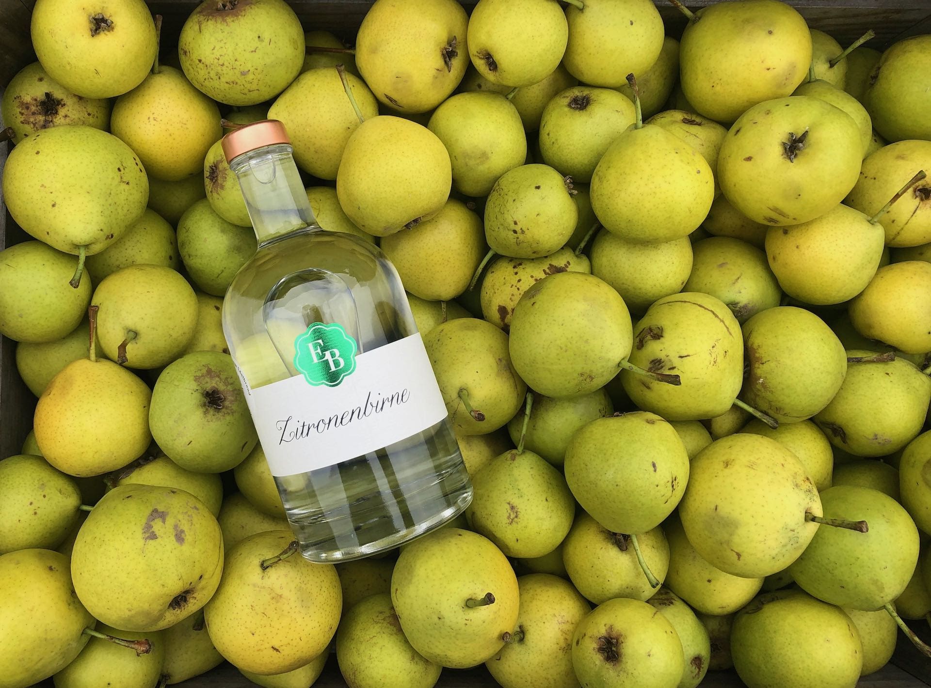 Geerntete Zitronenbirnen von lokalen Streuobst-Bäumen in einer Holzkiste der Destillerie Brunner.