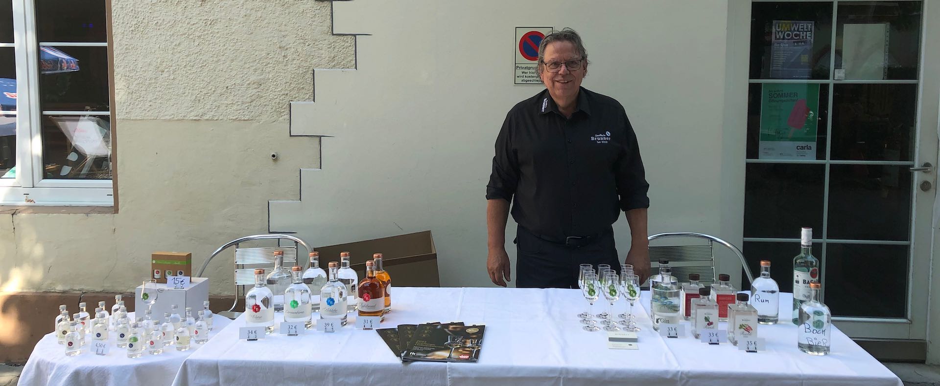 Egon beim Marktstand der Destillerie Brunner beim Local Heroes Event des Hotel Honolulu in Vorarlberg, Desktop Variante.